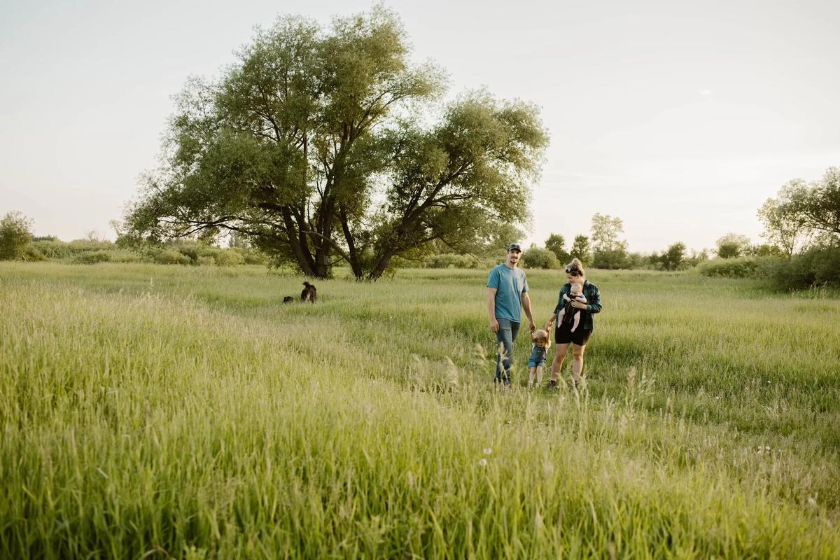 A family of four walking through a field
